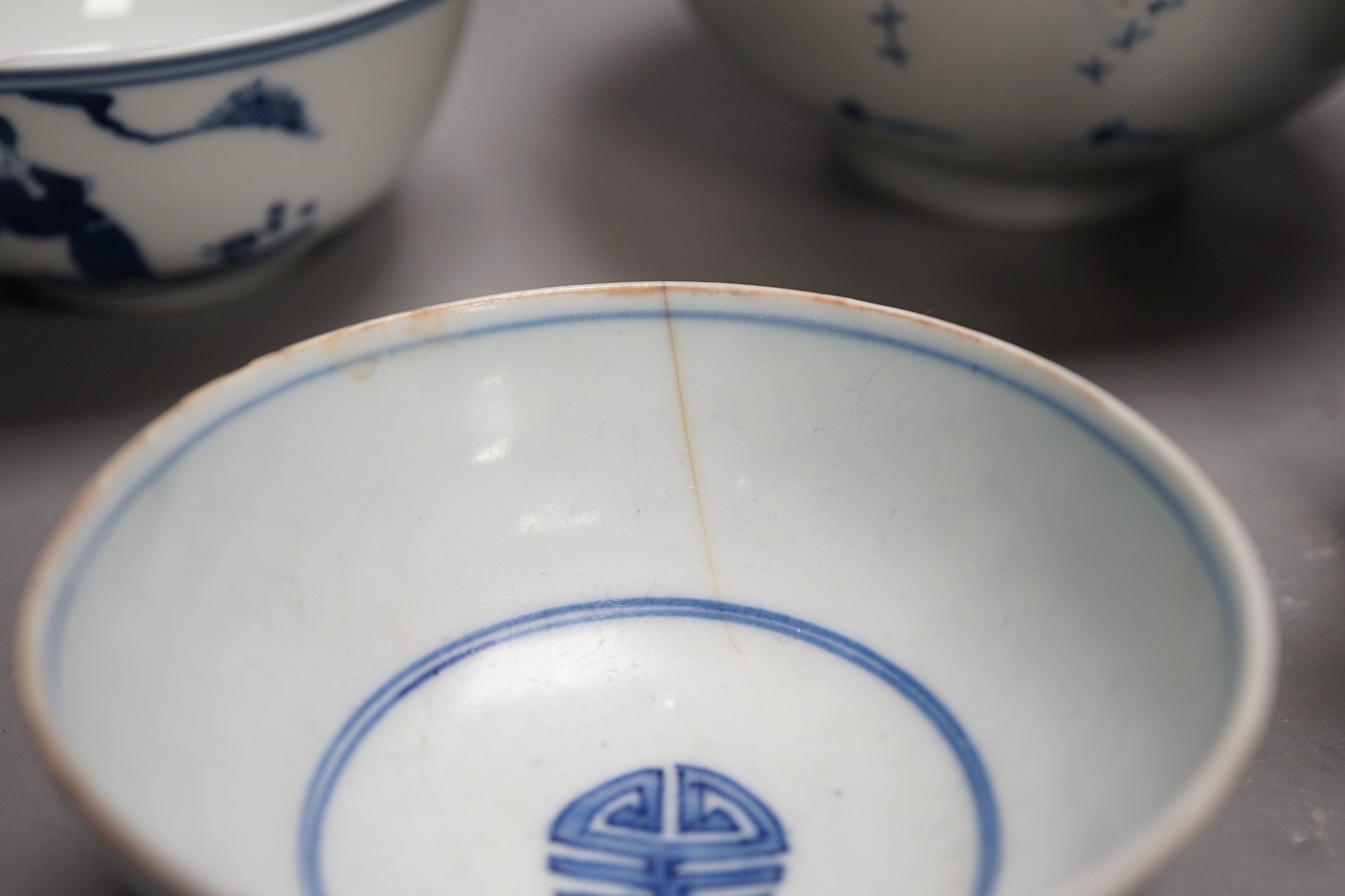 A Chinese Ming dynasty internally decorated porcelain tea bowl, an 18th century blue and white bowl, two other blue and white bowls, a similar water pot and an Islamic brass vessel